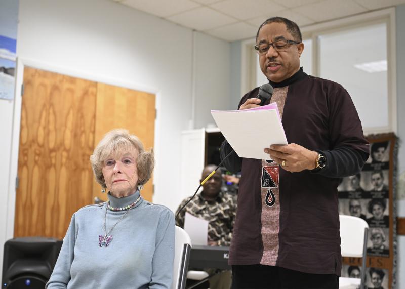 Violet Moore sits as her poem is read aloud by Pastor Vincent Hinds.